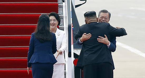 9月18日，韩国总统文在寅和夫人金正淑在平壤顺安国际机场同前来迎接的朝鲜国务委员会委员长金正恩和夫人李雪主热情寒暄。