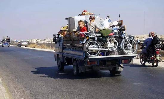 9月11日，在叙利亚伊德利卜省一条公路上，两名儿童坐在一辆卡车上。新华社/法新