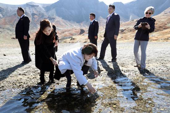 韩国第一夫人金正淑在天池取水，朝鲜第一夫人李雪主帮她提衣服。