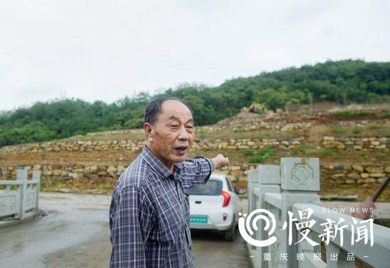  △李则民指着身后正在修建的层层梯田说：这里明年将是漂亮的花海