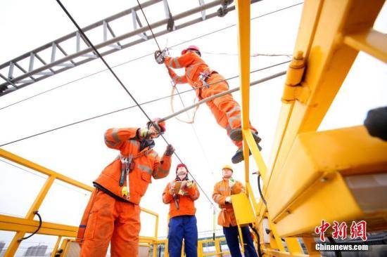 资料图：技术工人们正在对电气铁路段进行全面“体检”。中新社记者王舒摄