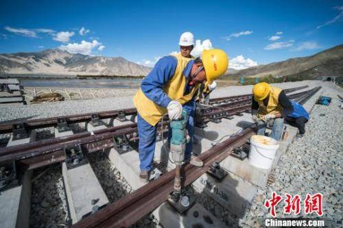 资料图：中铁十一局三公司施工人员在川藏铁路拉林段铺设首组道岔何蓬磊摄
