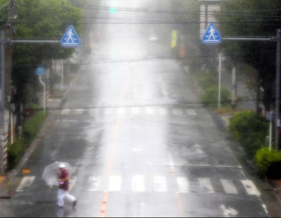 偶尔有人撑伞走过的那霸市街头（图片来源：朝日新闻）