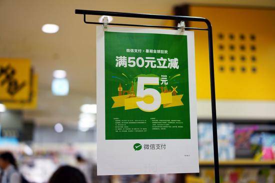 日本大阪的一个商场收银台上方悬挂的微信支付广告（图片来源：视觉中国）