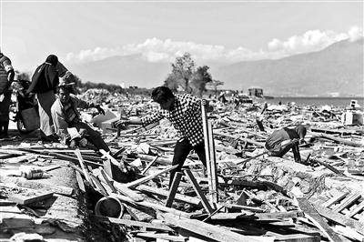 当地居民在清理被地震海啸夷为废墟的家乡供图/视觉中国