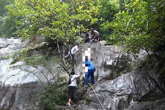 （9月20日，救援人员从泰国合艾市象牙瀑布下找回了中国女游客的尸体图片来源：《曼谷邮报》）