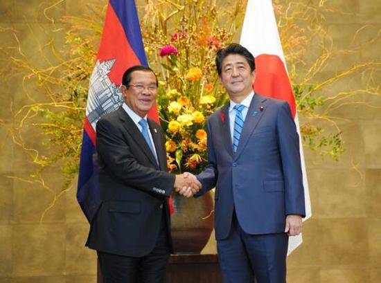 安倍与柬埔寨首相洪森握手（图片来源：日本《朝日新闻》）