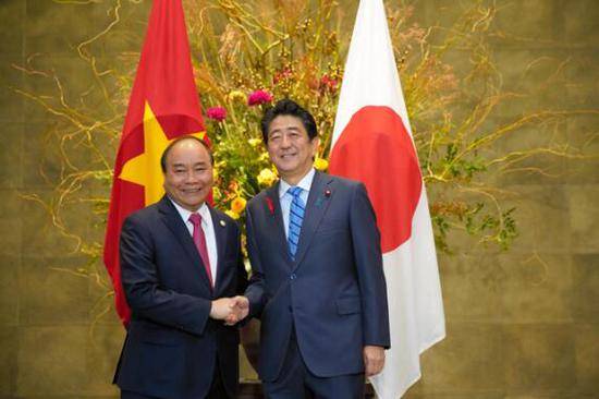 安倍在与越南总理阮春福握手（图片来源：日本《朝日新闻》）