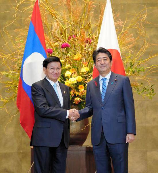 安倍与老挝总理通伦握手（图片来源：日本《朝日新闻》）