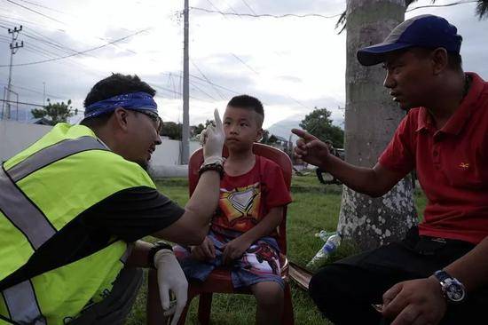 10月9日，在印尼帕卢灾区，中国志愿者都海郎正在为灾民看病。新华社记者王申摄
