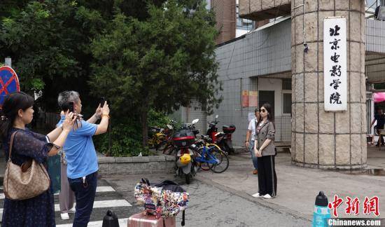 资料图：新生在北京电影学院校门口拍照。中新网记者 翟璐 摄