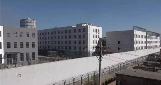 ▲组成监狱“大包围”的白色围墙有6米多高，墙上边是1米多高的电网。新京报记者孙旗摄