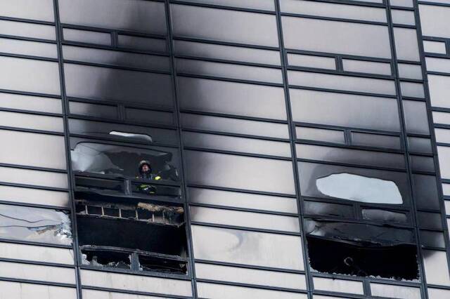 消防员在查看火灾现场来源：美联社