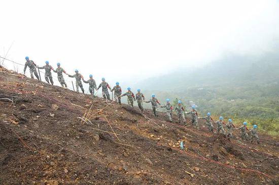 官兵牵手走过清排雷场，证明这片土地已绝对安全