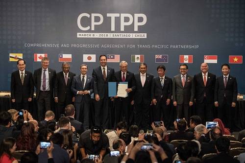 资料图片：2018年3月8日，在智利首都圣地亚哥，智利外长穆尼奥斯（中）与参与“全面与进步跨太平洋伙伴关系协定”（CPTPP）谈判的其他国家代表展示签署的协定文本。新华社发