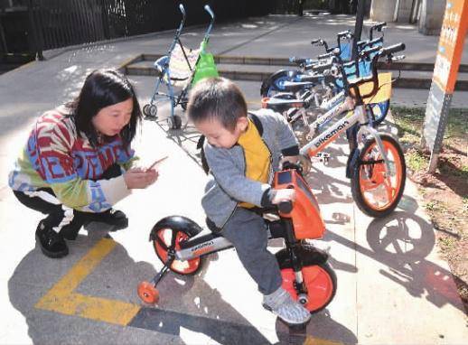 11月1日，长沙市天心区城市森林小区，一位家长用手机扫码给孩子取“儿童版”共享单车。记者田超摄