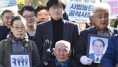 在法院门前合影的韩国受害劳工及家属。（日本共同社）