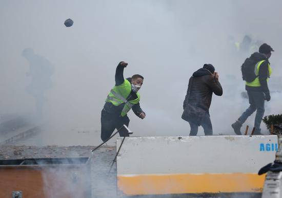 示威者向警戒线扔掷石块（图源：卫报）