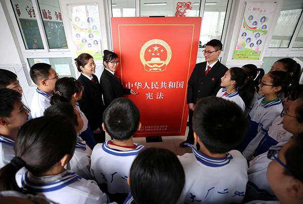 2018年12月3日，在河北省大厂回族自治县第二回民中学，普法志愿者为学生讲解宪法知识。视觉中国图