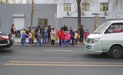 12月3日，北京，大风天气，放学后家长在寒风中接孩子们放学。图/视觉中国