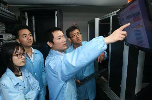 ▲在上海交通大学，金贤敏教授（右二）在实验室指导学生熟悉光量子芯片制备的要点。（新华社）
