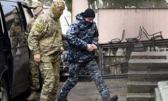 资料图片：俄联邦安全局人员押送被俘乌军士兵（蓝色迷彩服者）照片（图片来源于网络）