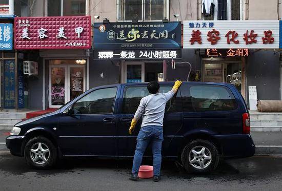 12月1日，辣椒在店门口擦洗自己的车，第二天要当出殡的头车。