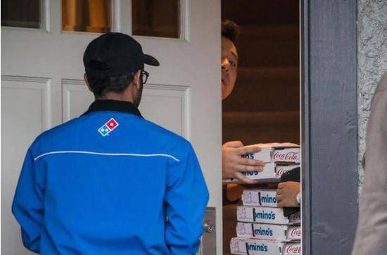据媒体在孟晚舟家外拍摄到的照片显示，孟晚舟的老公亲自接收了披萨的外卖。（图片来源：彭博社）