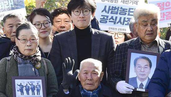 在法院门前合影的韩国受害劳工及家属（共同社）