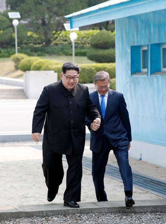 朝韩领导人手拉手跨过板门店水泥军事分界线。（韩联社）