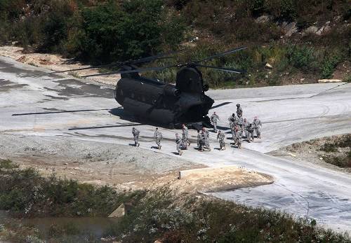 2011年9月30日，在韩国抱川的一个军事训练基地，参加军演的美军士兵从一架军用直升机中走出。新华社发