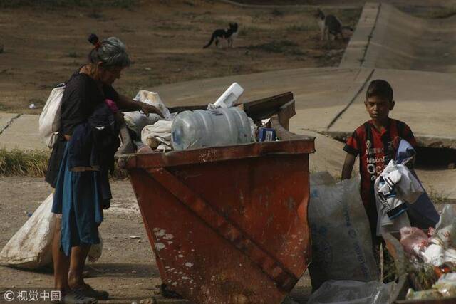 2018年6月7日，委内瑞拉苏利亚州圣弗朗西斯科市，民众在垃圾堆中翻找食物。图自视觉中国