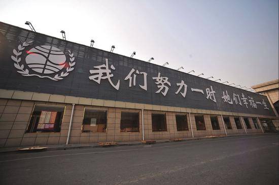 天津权健总部的一处外墙上的标语：我们努力一时她们幸福一生。