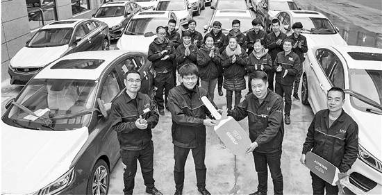 研发部副部长何平（左二）接过车钥匙。