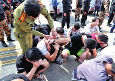老挝警方给犯罪嫌疑人打开手铐，准备登机。大河报图