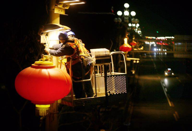 1月22日凌晨，电力工人在长安街安装春节灯笼。摄影/新京报记者侯少卿