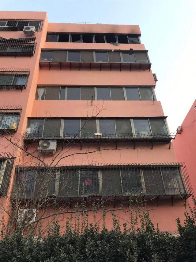 6楼被大火熏黑的外墙和破碎的玻璃，柏某才杀害全家后从另一侧房间跳窗坠楼身亡。