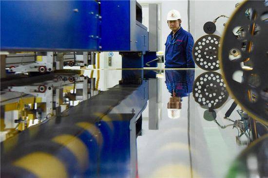 ↑1月9日，在中建材蚌埠玻璃工业设计研究院的生产车间内，工作人员在巡检超薄玻璃生产线。新华社记者汤阳摄