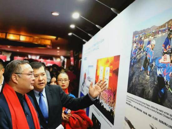 我驻洛杉矶总领事张平大使（左）观看北京冬奥会和冬残奥会图片展