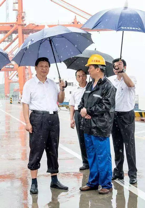 2013年7月21日，习近平冒雨来到武汉新港阳逻集装箱港区。雨下得很大，积水没过了脚面。他卷起裤腿，打着雨伞，向工作人员了解物流等情况。