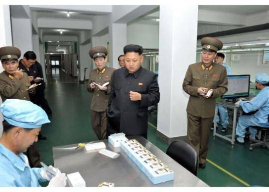 2013年，金正恩视察朝鲜一家制造手机的工厂。（韩联社）