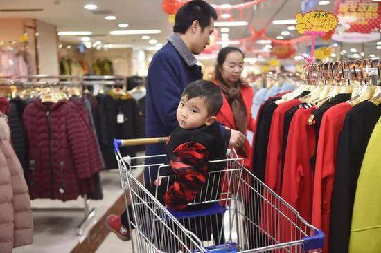 黄海龙、黄爱华带着小聪聪在超市选购过年回家送家人的衣服。