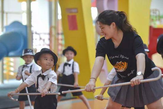 在福建省石狮市鹏博幼儿园，聪聪（左）跟着老师林慧芬排练“六一”节目。