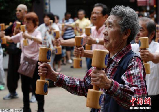 资料图：日本老人们手持木质哑铃齐跳“广场舞”。