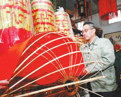 北京市美术红灯厂工人将红色布料贴在骨架上。本报记者贺勇摄。
