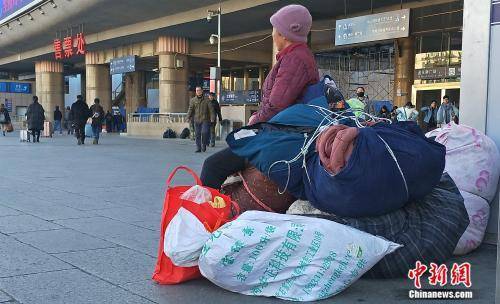 资料图：正在车站外候车的旅客。姚露摄