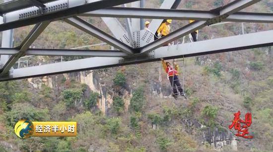 △李逸活动悬梯对钢梁底下的高强螺栓进行检查