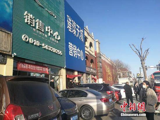 2月20日，几名销售人员在售楼处外闲聊。中新网记者邱宇摄