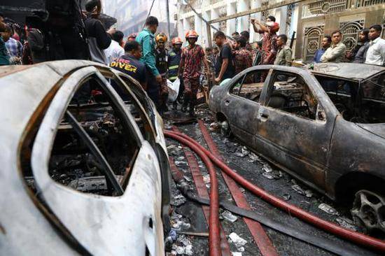 2月21日，在孟加拉国达卡，工作人员在火灾现场转移遇难者遗体。新华社图