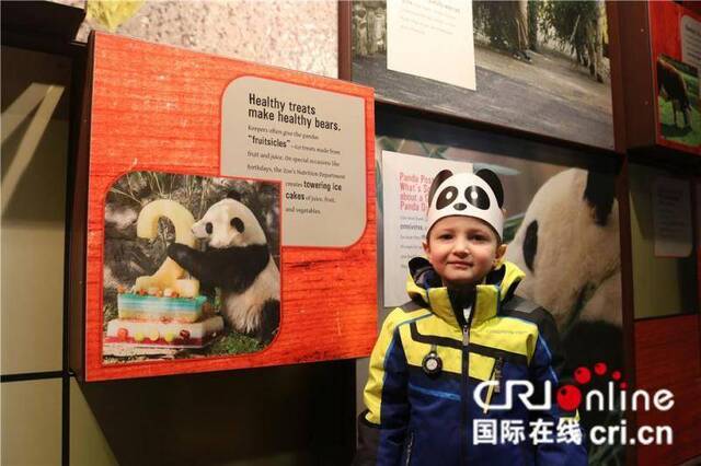 美国小朋友在熊猫馆内与展示墙合影。（摄影刘坤）